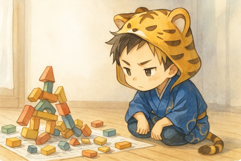 積み上げていた積み木がガラガラと崩れてしまった瞬間。しかし大雅は怒ったりせず、「そっか、ここの土台が弱かったのか」と崩れた積み木を分析するように眺めている。